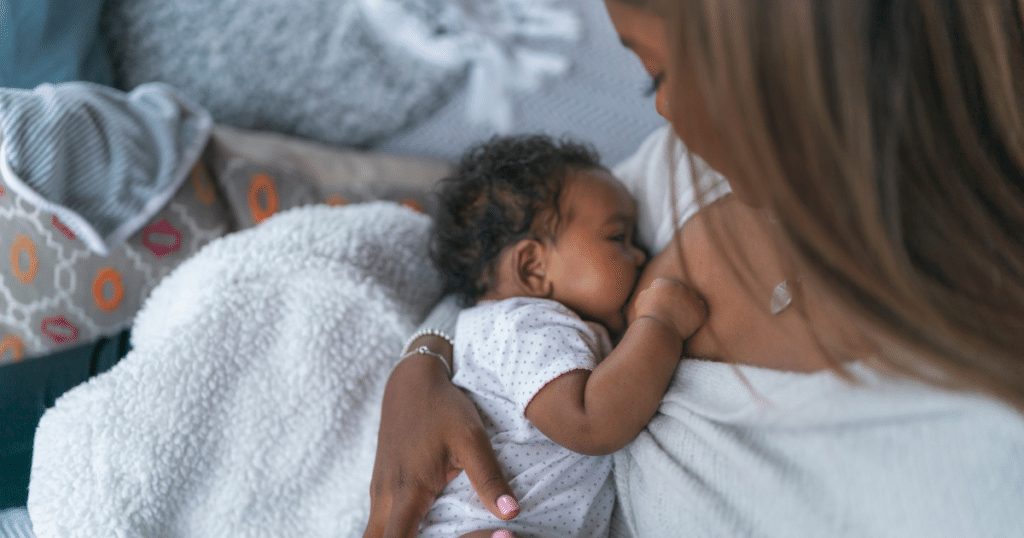 A parent feeding and soothing their newborn.